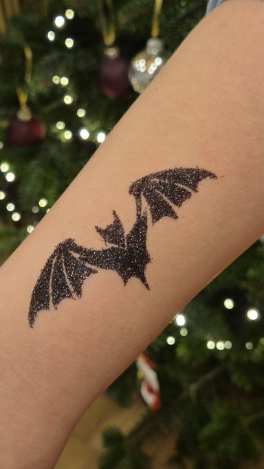 Fledermaus Glitzertattoo Weihnachtsmarkt in Seevetal Hochwertiges Glitzertattoos, professionell umgesetzt von Faceglimmer auf dem Weihnachtsmarkt in Seevetal